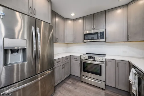 a kitchen with stainless steel appliances granite countertop a refrigerator stove and microwave