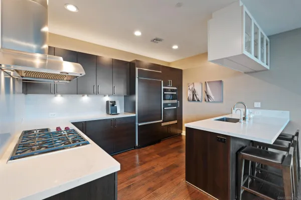 a kitchen with kitchen island a counter top space appliances and a sink