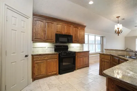 a kitchen with a stove a sink and a microwave