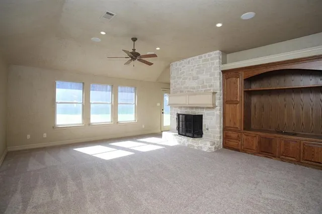 a view of an empty room with a fireplace and a window