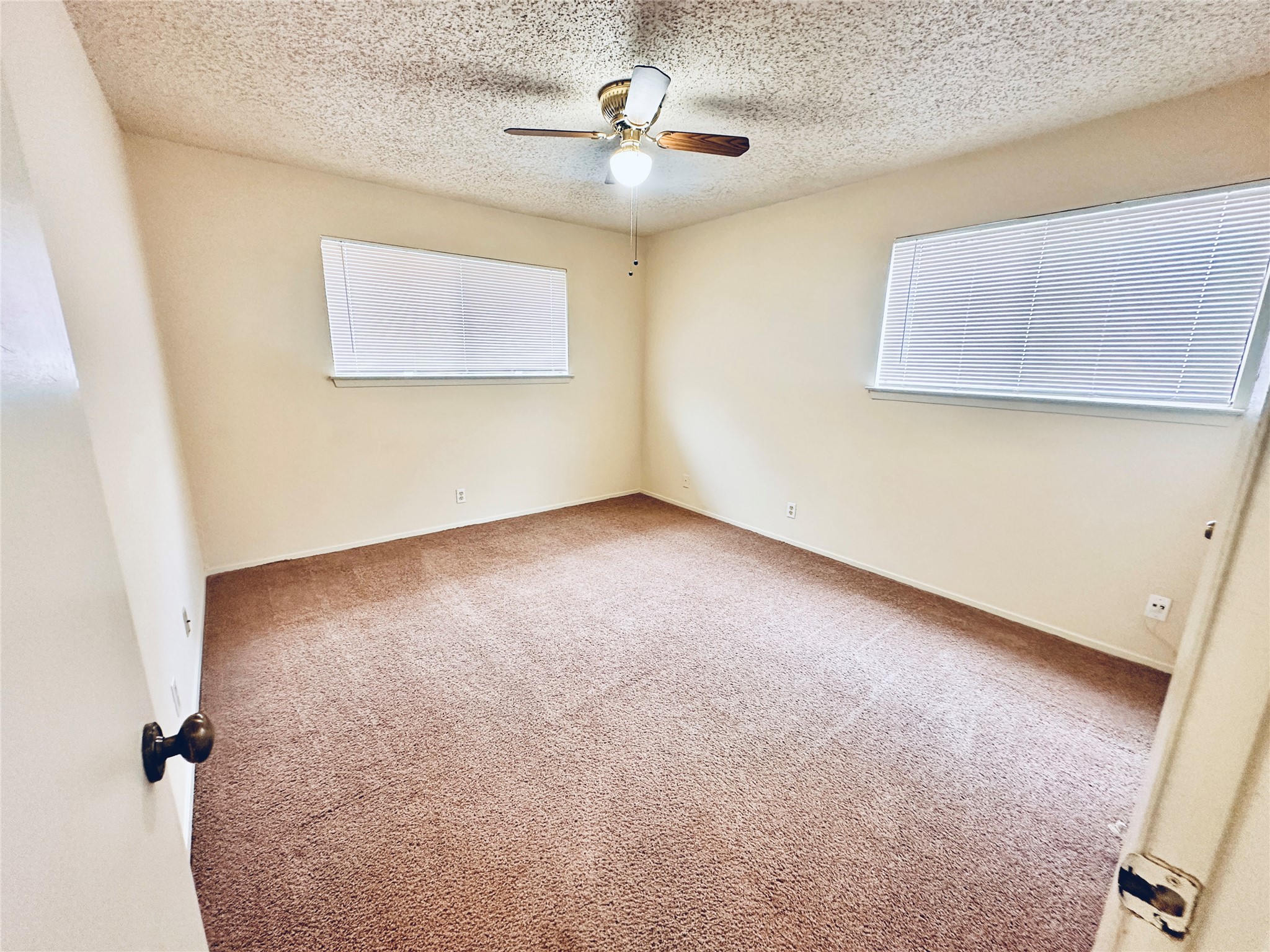 12504 Tree Line Drive, Unit B Austin, TX 78729 - Photo 15 of 22 Carpeted spare room featuring a ceiling fan, a textured ceiling, and plenty of natural light