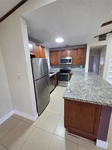 a kitchen with stainless steel appliances granite countertop a refrigerator and a sink