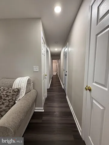 a hallway with white couches with wooden floor