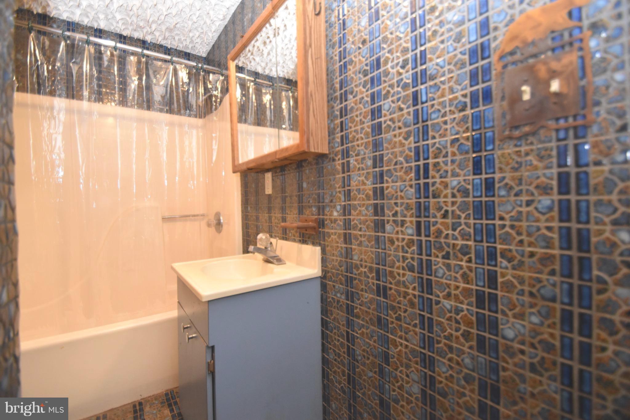 5638 Prince George Street Baltimore, MD 21207 - Photo 9 of 15 a bathroom with a sink a mirror and a shower