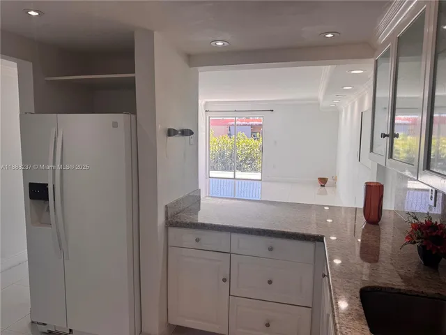 a kitchen with stainless steel appliances granite countertop a sink a stove and a granite counter top