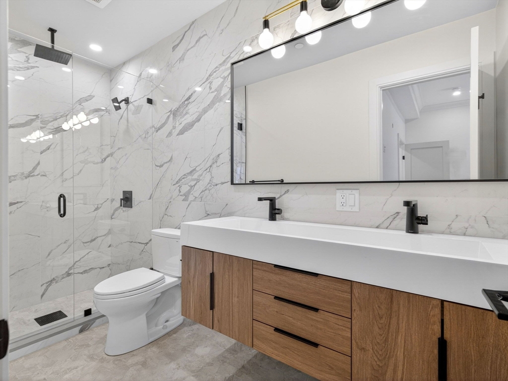 427 East 6th Street, Unit 1 Boston, MA 02127 - Photo 16 of 30 a bathroom with a sink a toilet and a mirror