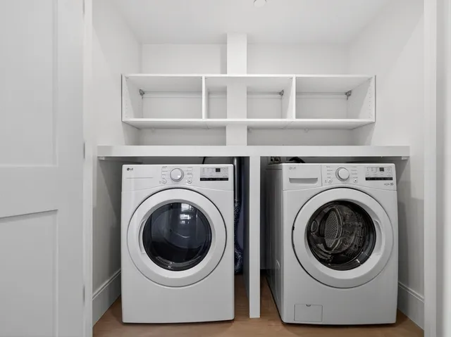 a view of an empty room with wooden floor and windows