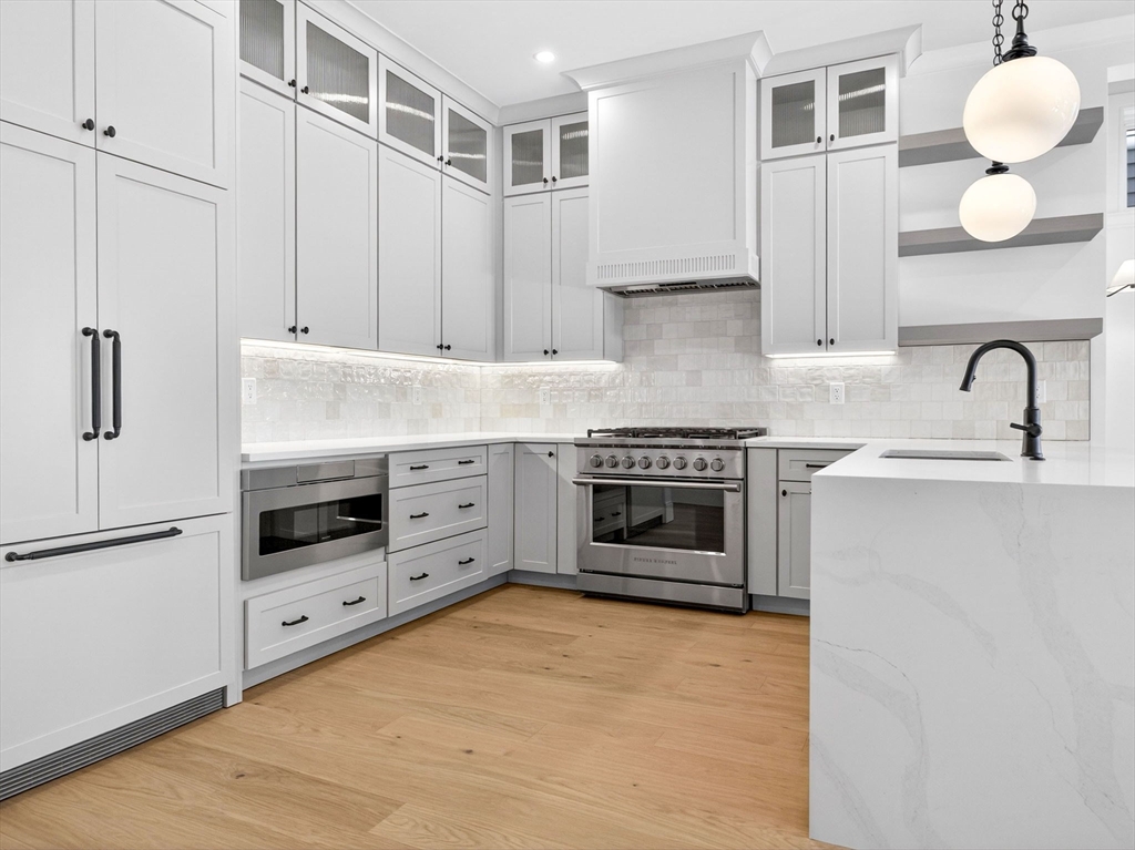 427 East 6th Street, Unit 1 Boston, MA 02127 - Photo 3 of 30 a kitchen with stainless steel appliances granite countertop a stove a sink and a refrigerator