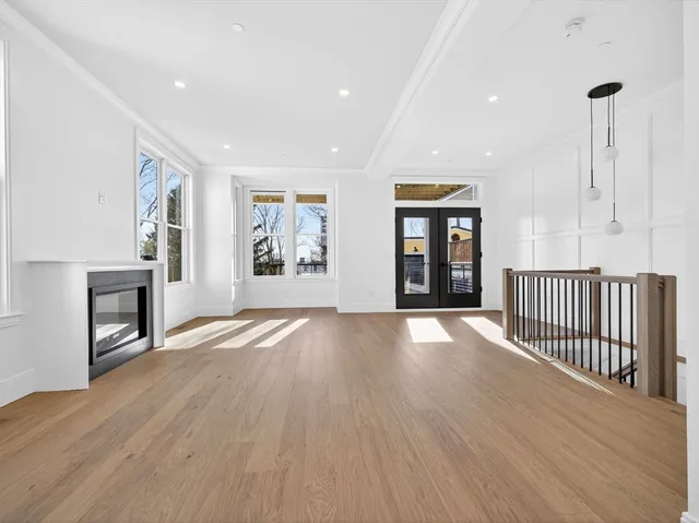 an empty room with windows and fireplace