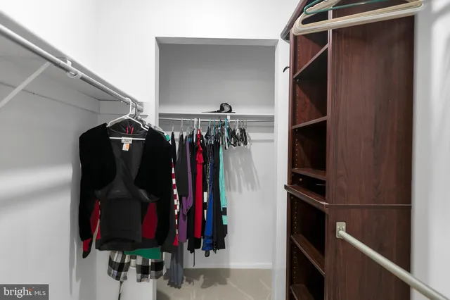 a view of walk in closet with clothes and shoes