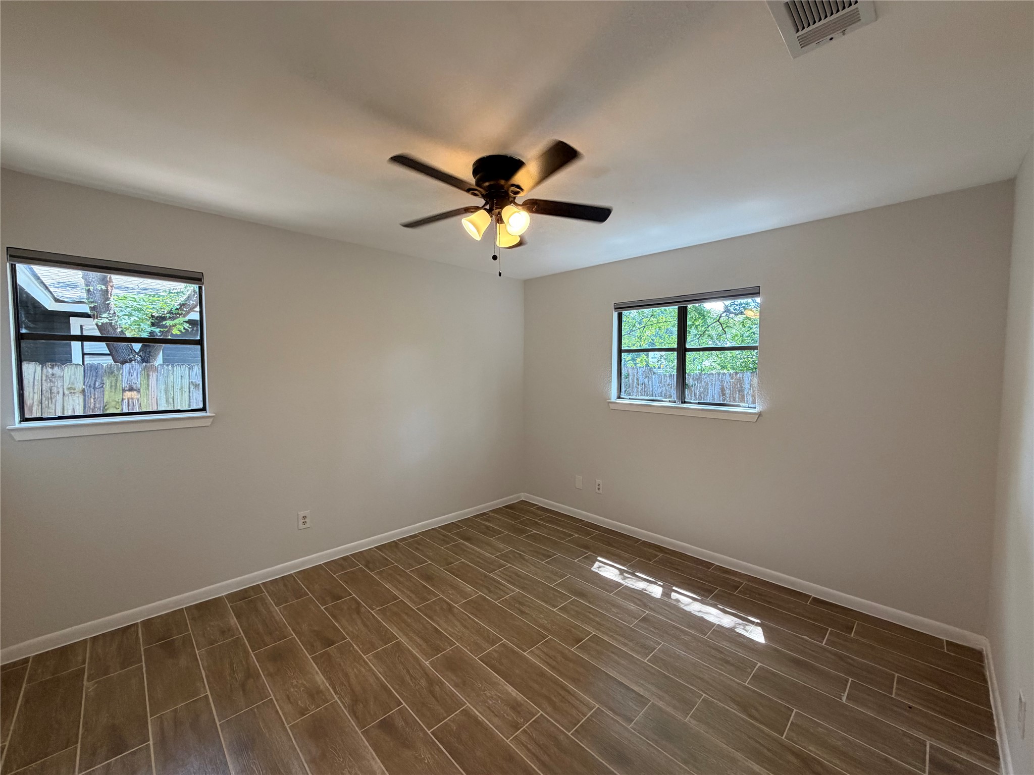 604 Gaylor Street, Unit B Austin, TX 78752 - Photo 4 of 5 A well-lit bedroom features durable tile flooring and a functional ceiling fan.