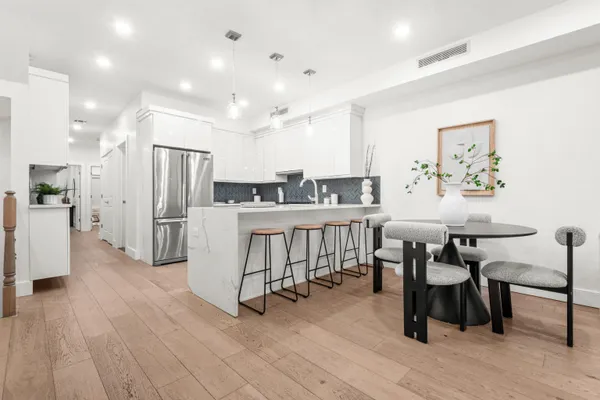 a living room with stainless steel appliances kitchen island granite countertop furniture and a wooden floor