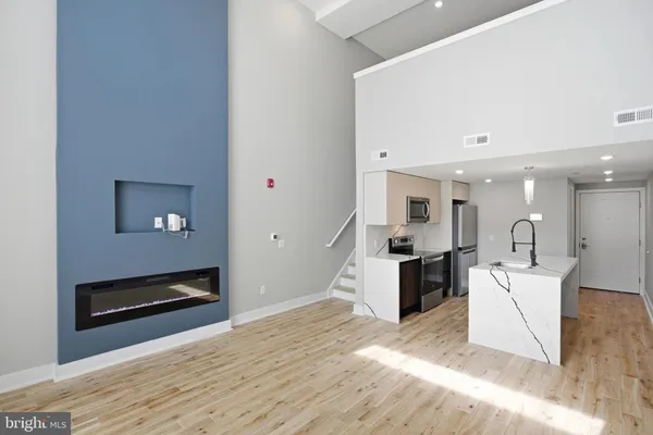 a kitchen with stainless steel appliances granite countertop a refrigerator a sink a stove a microwave and cabinets