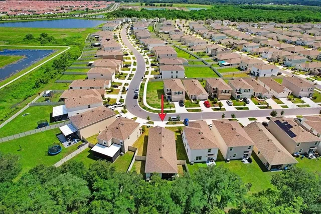 an aerial view of residential houses with outdoor space and parking
