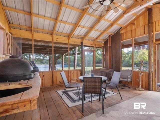 4650 Wiggins Lane Wilmer, AL 36587 - Photo 57 of 66 Sunroom with wooden walls, hardwood / wood-style flooring, a water view, and lofted ceiling