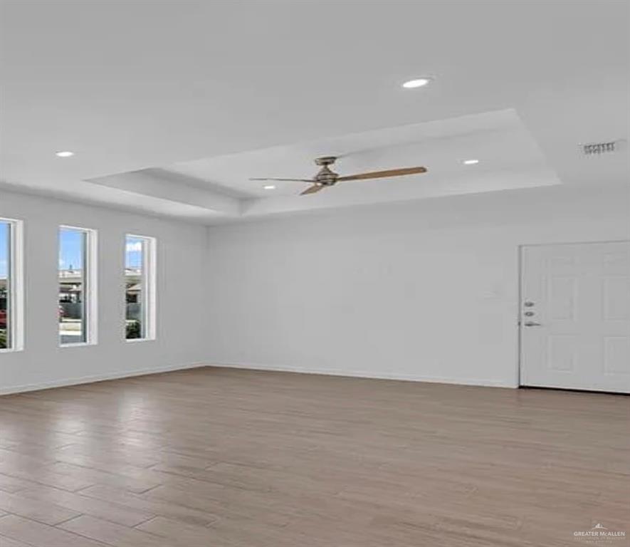 1403 Marcela Drive, Unit 1 Weslaco, TX 78599 - Photo 5 of 13 Empty room with a tray ceiling, light wood finished floors, recessed lighting, and a ceiling fan