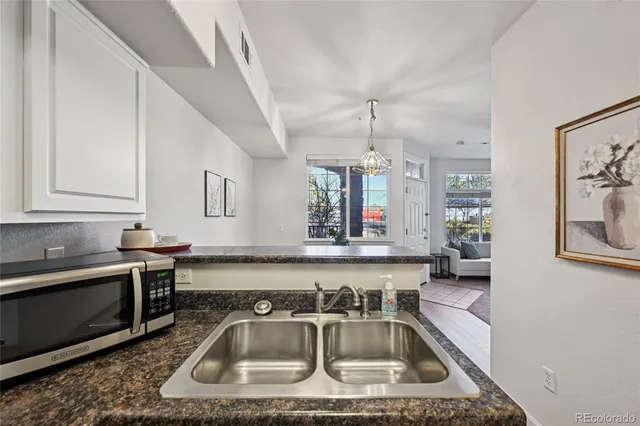 a kitchen with a sink a counter top space cabinets and stainless steel appliances