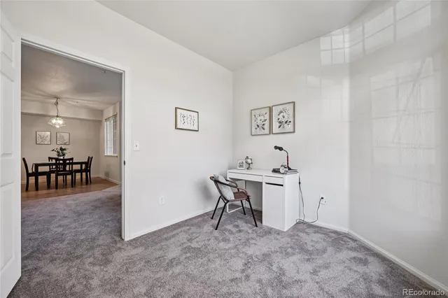 a view of a workspace with furniture and a window