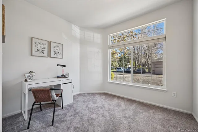 a view of a workspace with furniture and a window