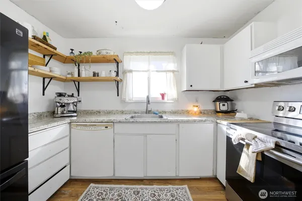 a kitchen with stainless steel appliances granite countertop a sink stove and cabinets