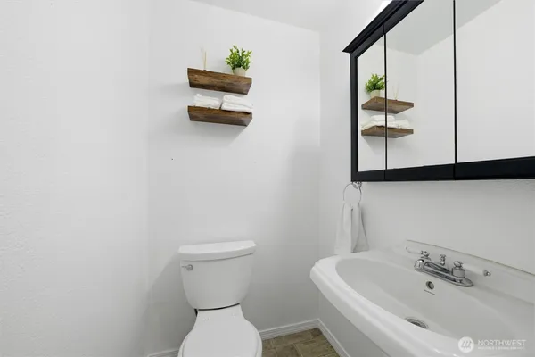 a bathroom with a toilet sink and mirror