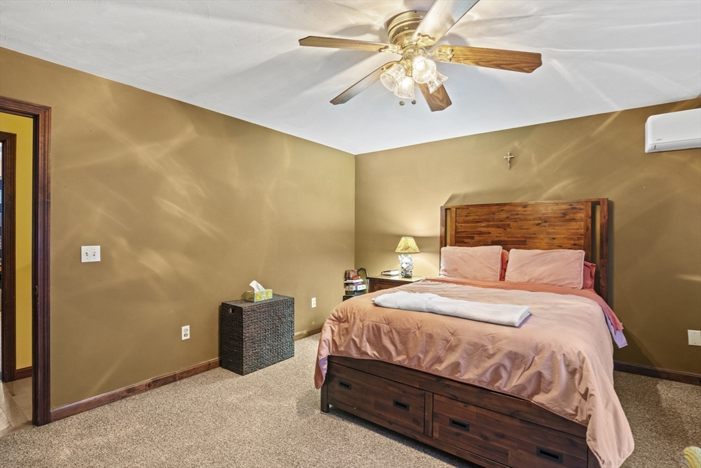 4 Wilson Way Rutland, MA 01543 - Photo 16 of 32 a bedroom with a bed and a chandelier