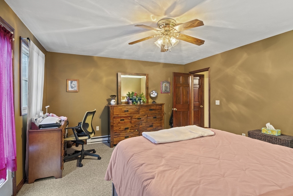 4 Wilson Way Rutland, MA 01543 - Photo 18 of 32 a bedroom with a bed and a chandelier