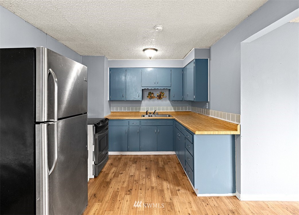 2619 Northeast 9th Street Renton, WA 98056 - Photo 8 of 25 a kitchen with stainless steel appliances granite countertop a refrigerator and a sink