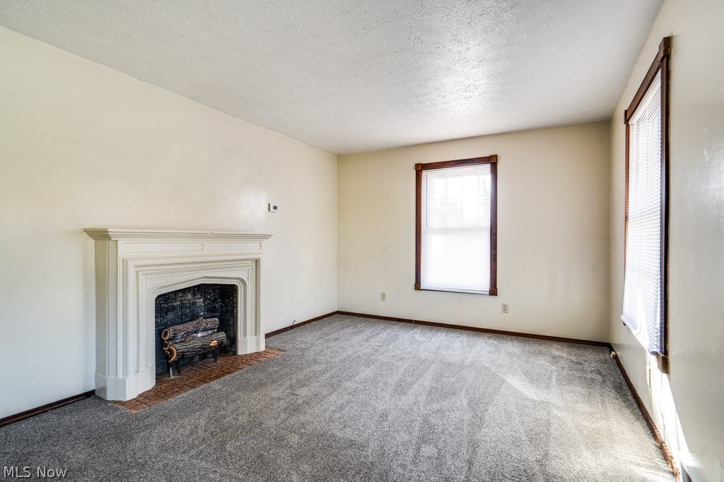 3693 Fishcreek Road Stow, OH 44224 - Photo 13 of 23 Unfurnished living room with dark carpet and a textured ceiling