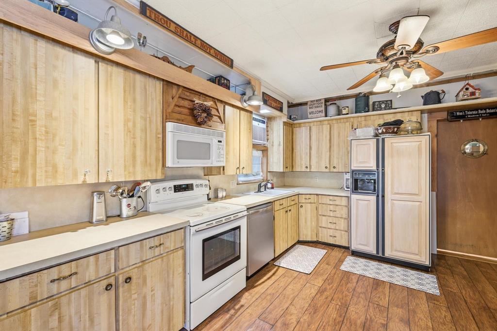 4513 Chapel Road Graham, TX 76450 - Photo 11 of 38 a kitchen with a sink cabinets stainless steel appliances and a window
