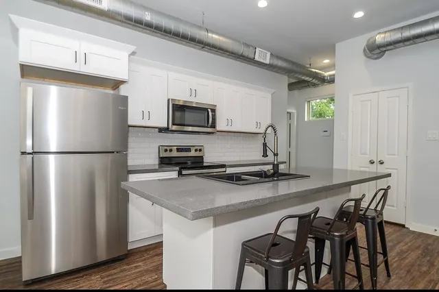 a kitchen with stainless steel appliances a refrigerator a stove a sink dishwasher and microwave