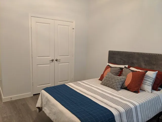 a bedroom with a bed and a wooden floor