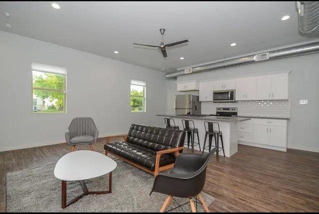 a living room with furniture a window and kitchen appliances