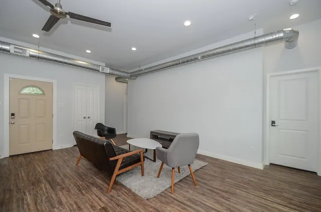 a living room with furniture and a wooden floor
