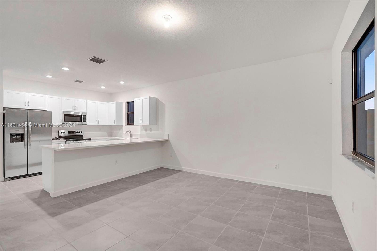 13405 Southwest 285th Street, Unit 13405 Homestead, FL 33033 - Photo 5 of 59 a large white building with kitchen view
