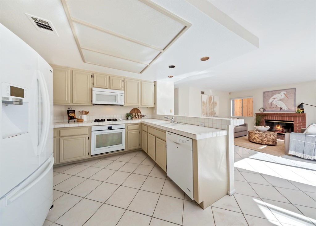 1593 Dawson Drive Vista, CA 92081 - Photo 16 of 40 a kitchen with cabinets and white appliances