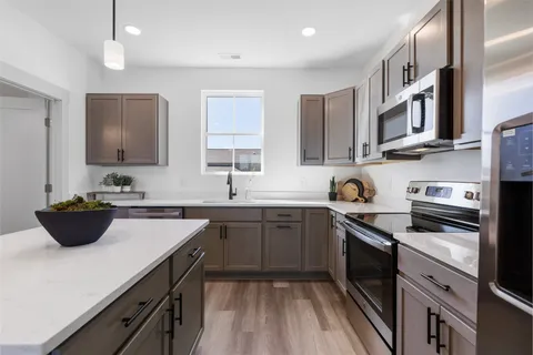 a kitchen with stainless steel appliances a sink stove and cabinets