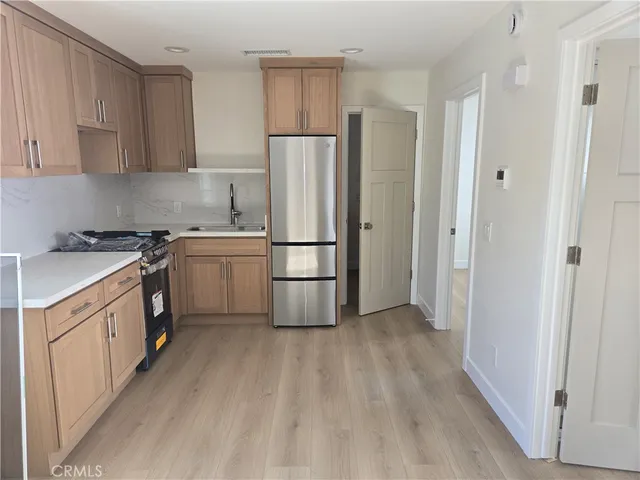a kitchen with a sink a refrigerator and a stove top oven