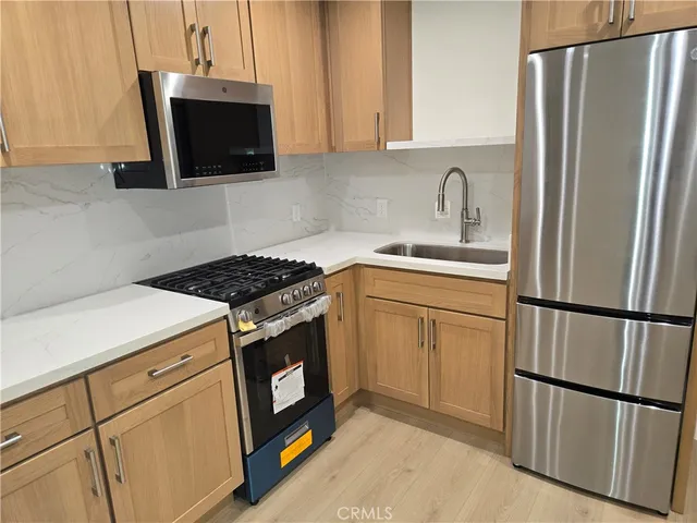 a kitchen with appliances a sink and cabinets