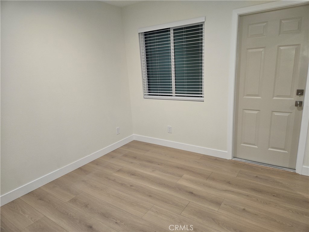 8712 Oceanview Avenue, Unit B Orange, CA 92865 - Photo 7 of 9 an empty room with wooden floor and windows