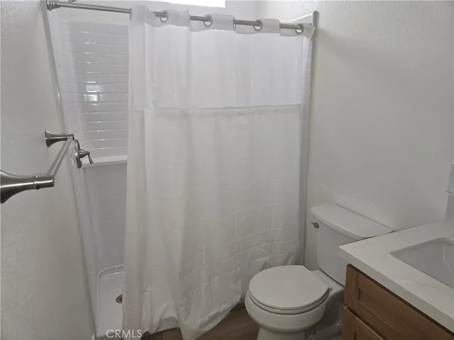 a white toilet sitting next to a shower