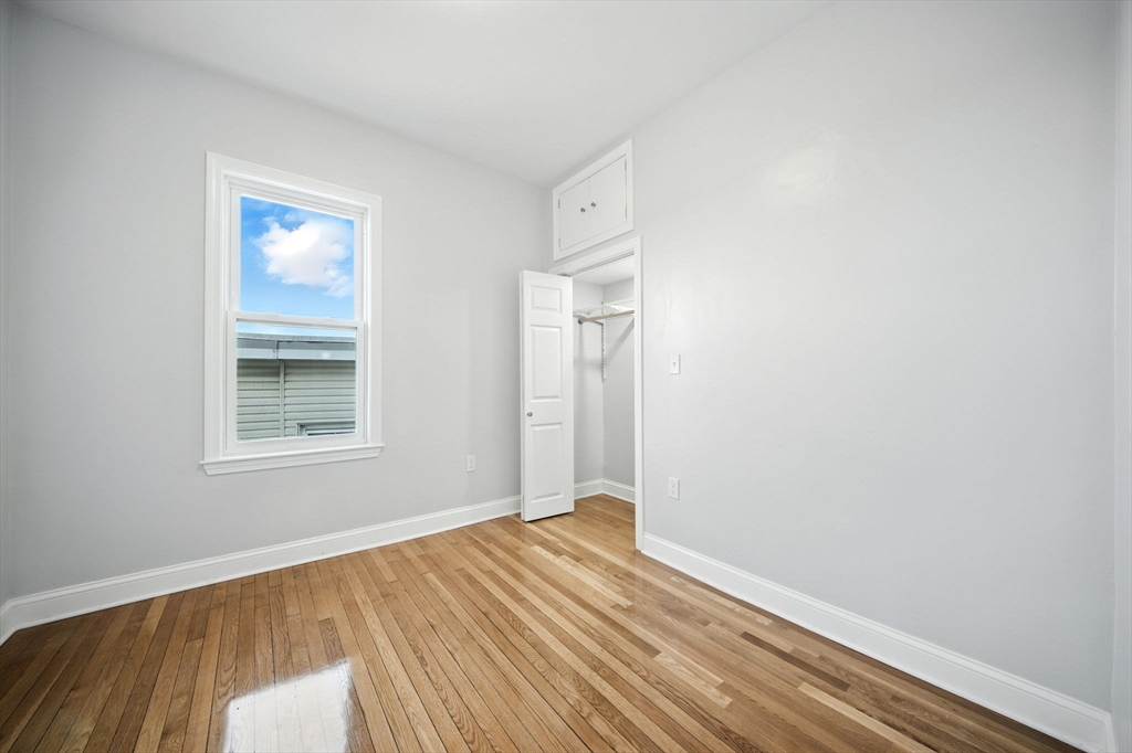 155 Wellington Hill Street, Unit 3 Boston, MA 02126 - Photo 15 of 20 a view of an empty room with wooden floor and a window