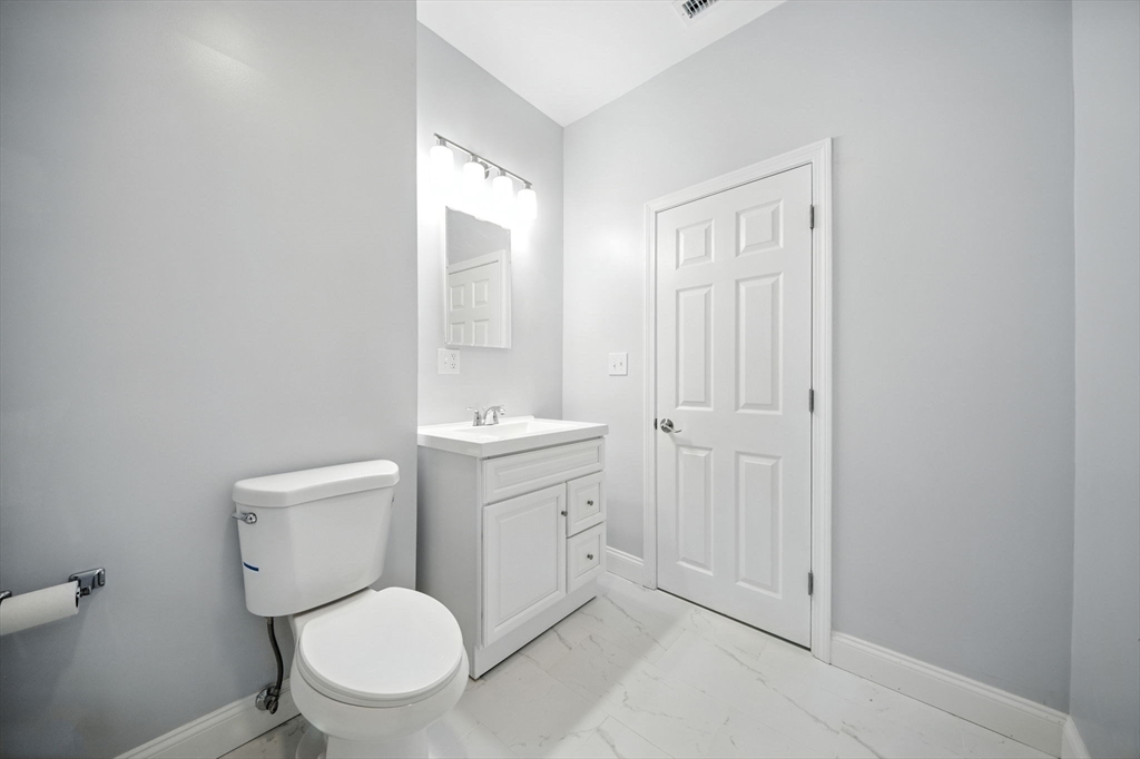 155 Wellington Hill Street, Unit 3 Boston, MA 02126 - Photo 17 of 20 a bathroom with a toilet a sink and mirror