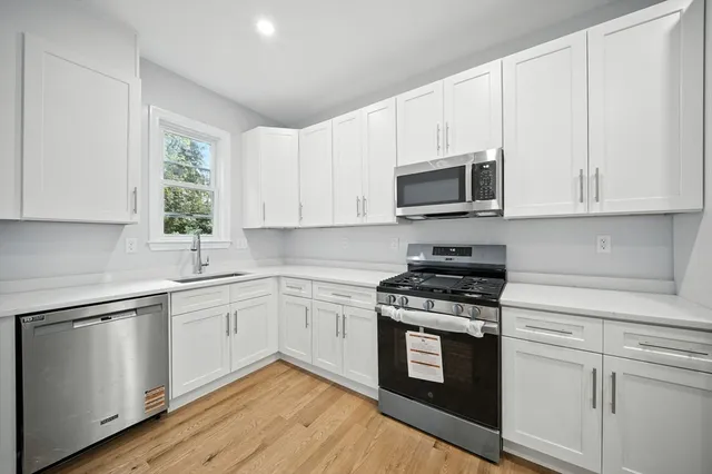 a kitchen with white cabinets and appliances