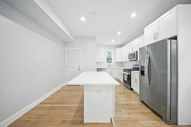 a kitchen with stainless steel appliances a refrigerator and a stove top oven