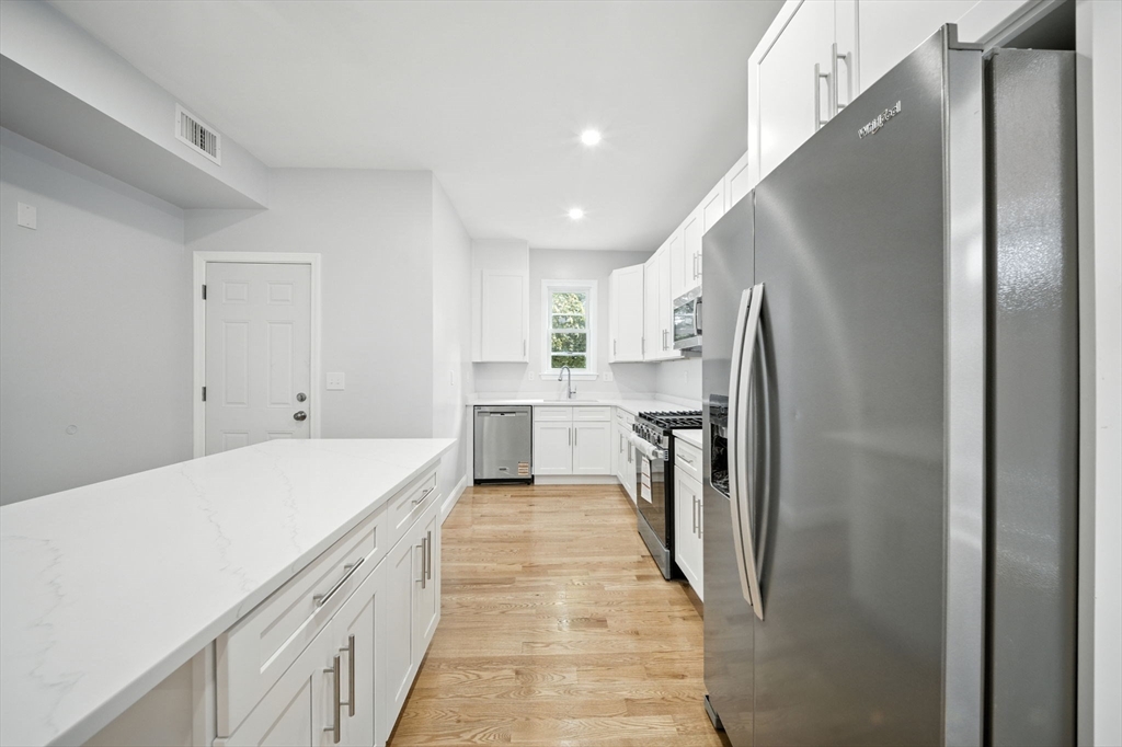155 Wellington Hill Street, Unit 3 Boston, MA 02126 - Photo 5 of 20 a kitchen with a refrigerator a sink and dishwasher