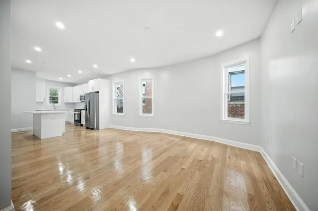 a view of an empty room with wooden floor