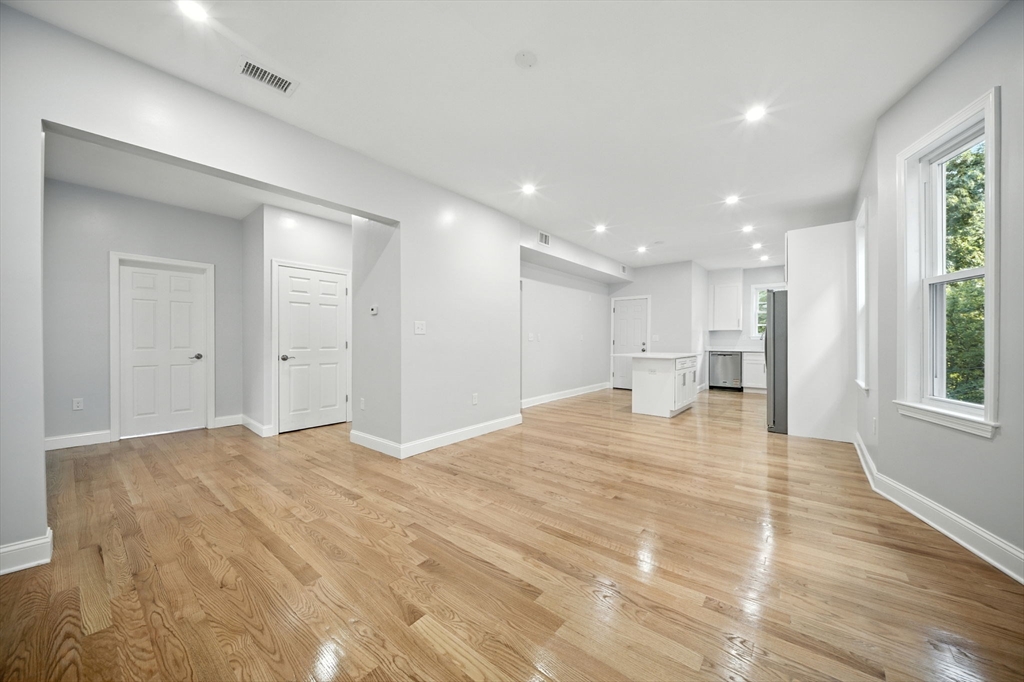155 Wellington Hill Street, Unit 3 Boston, MA 02126 - Photo 7 of 20 a view of an empty room with wooden floor and a window