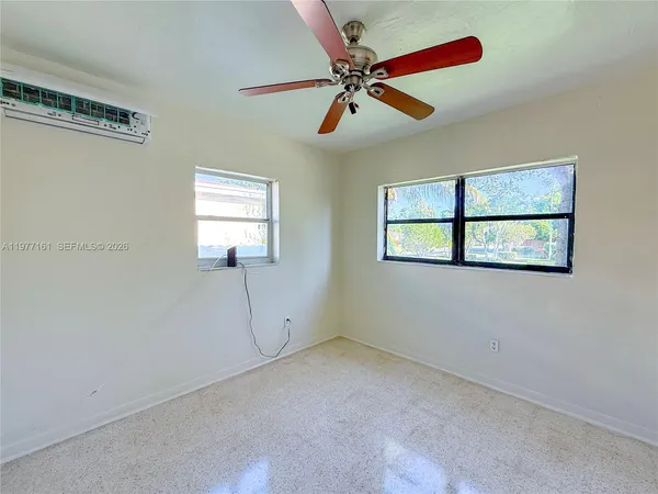 a view of empty room with window and ceiling fan