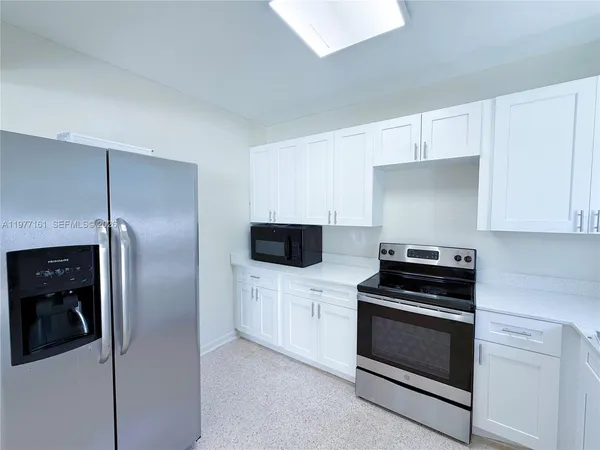 a kitchen with white cabinets and stainless steel appliances